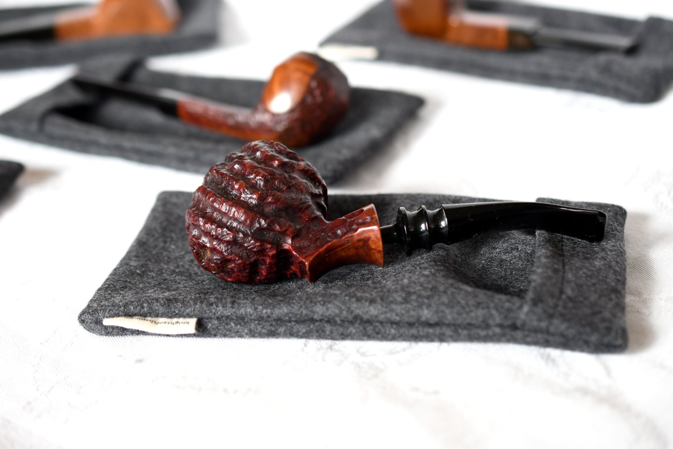 Three pipe socks with tobacco pipes sitting on top of them. 